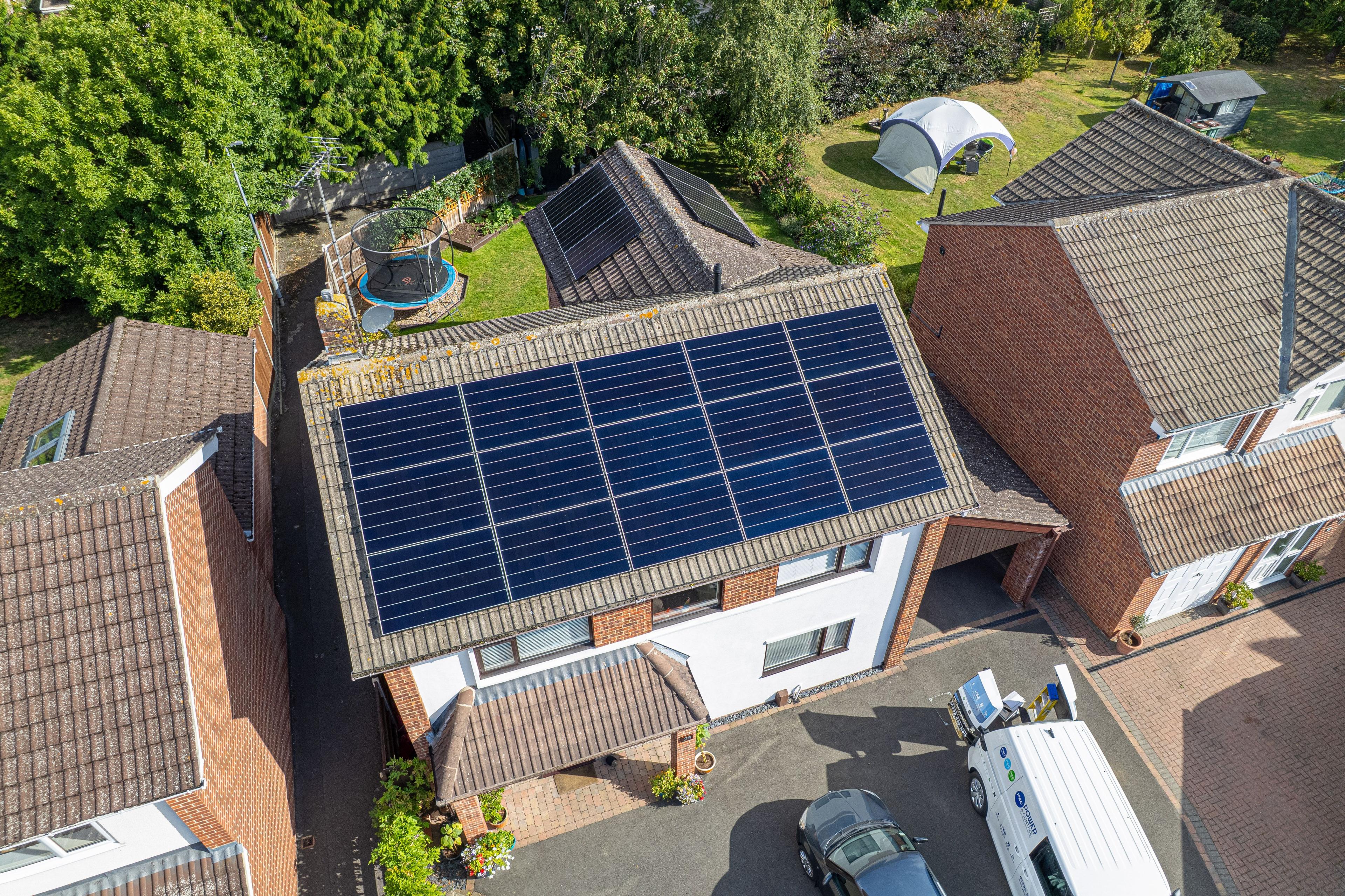 Aerial view of a full solar panel array on the roof of a house in Duffield, Derby, with a P&C van on the drive.