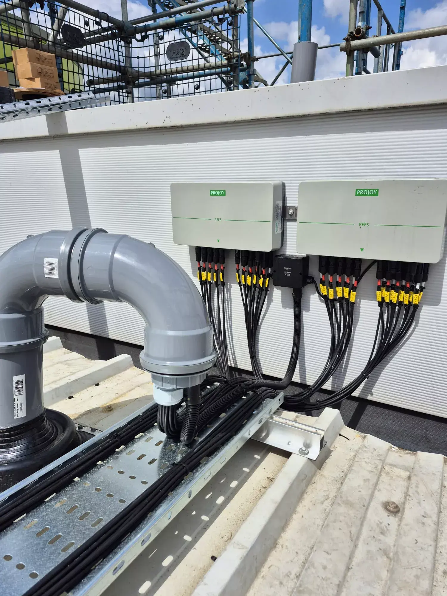 Two rooftop solar DC enclosures with string cables run through cable tray on a commercial roof.